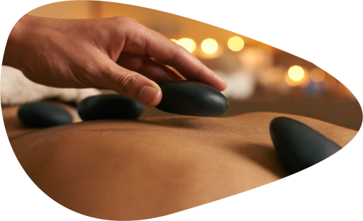 Une praticienne pratiquant un massage au pierres chaudes